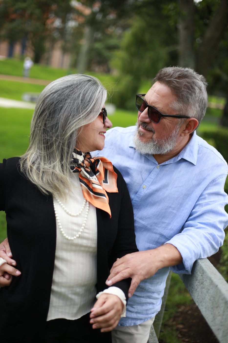 Casal maduro de óculos escuros, sorrindo um para o outro em um parque