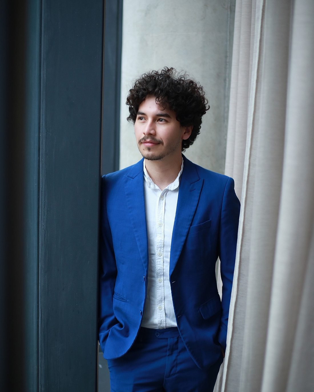 Retrato corporativo de homem de terno azul, olhando pela janela